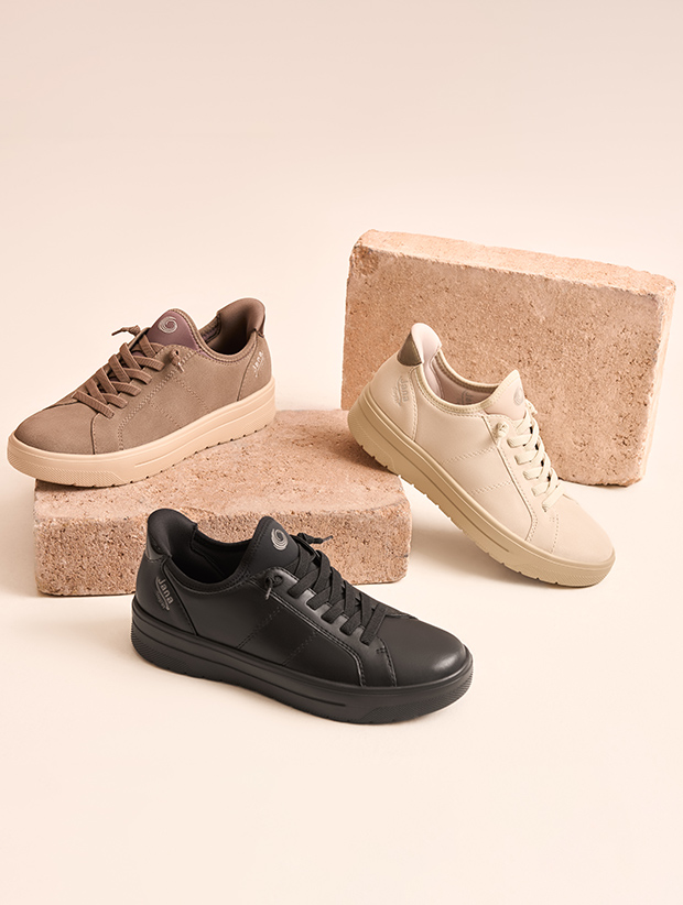 drei Sneaker angeordnet auf zwei Steinen