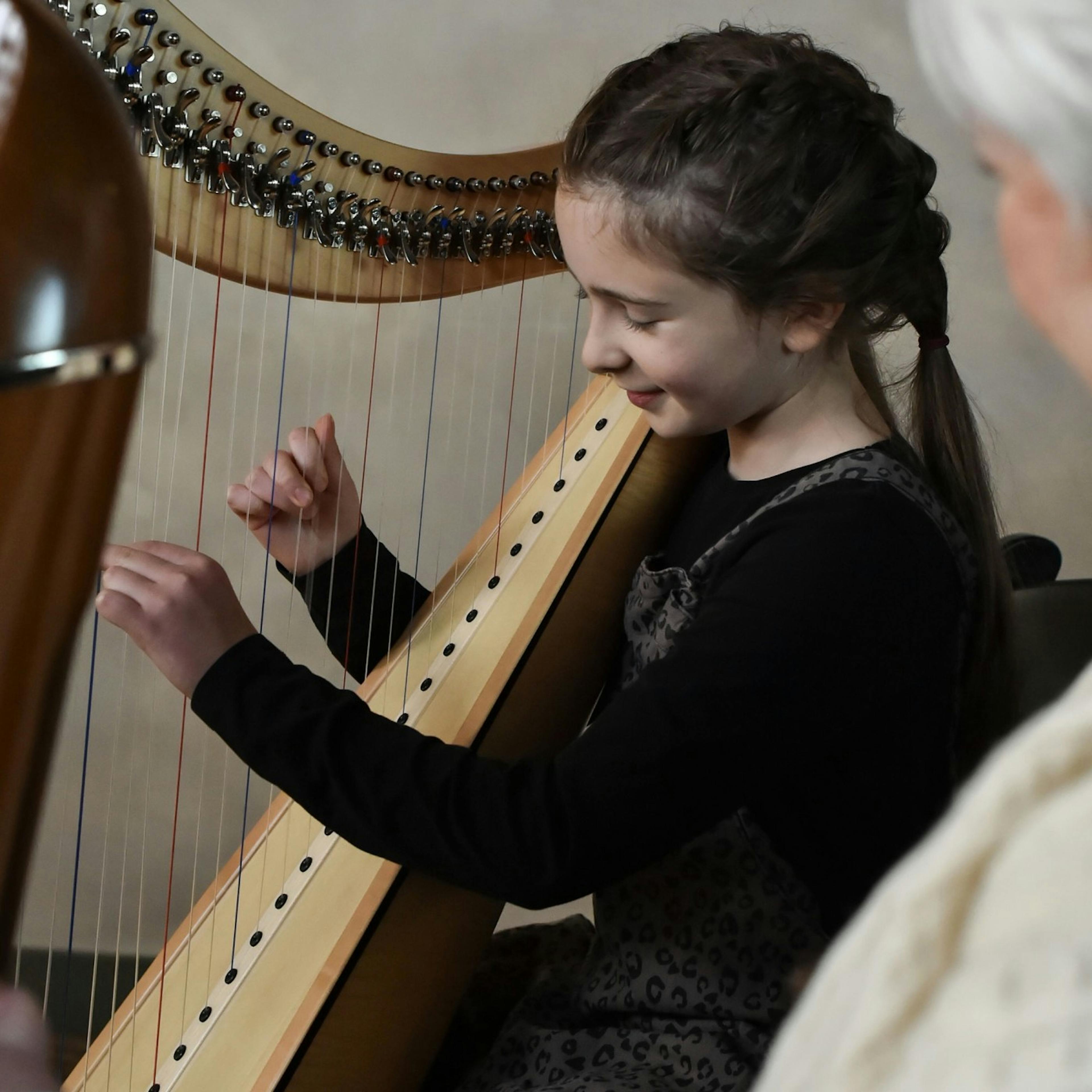 Young girl playing harp