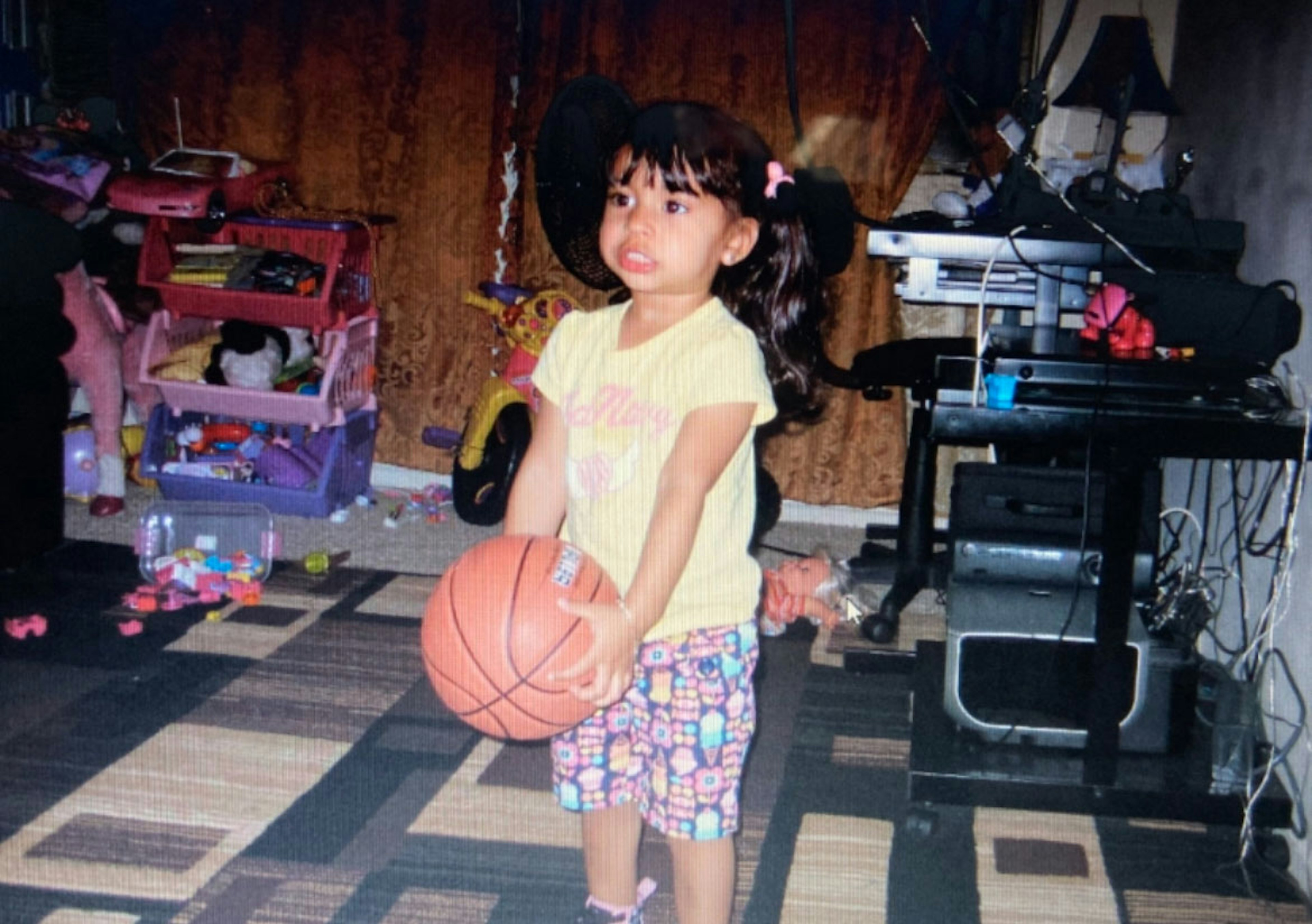 Jatniel as a younger kid holding a basketball.