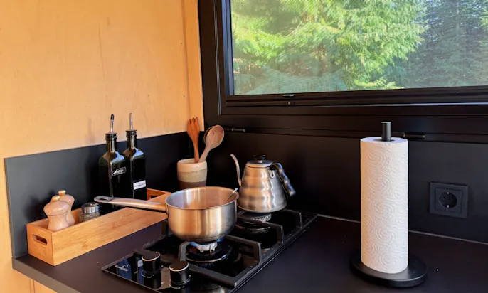 Ein Topf und ein Wasserkocher auf einem Herd in einem Raus Tiny House
