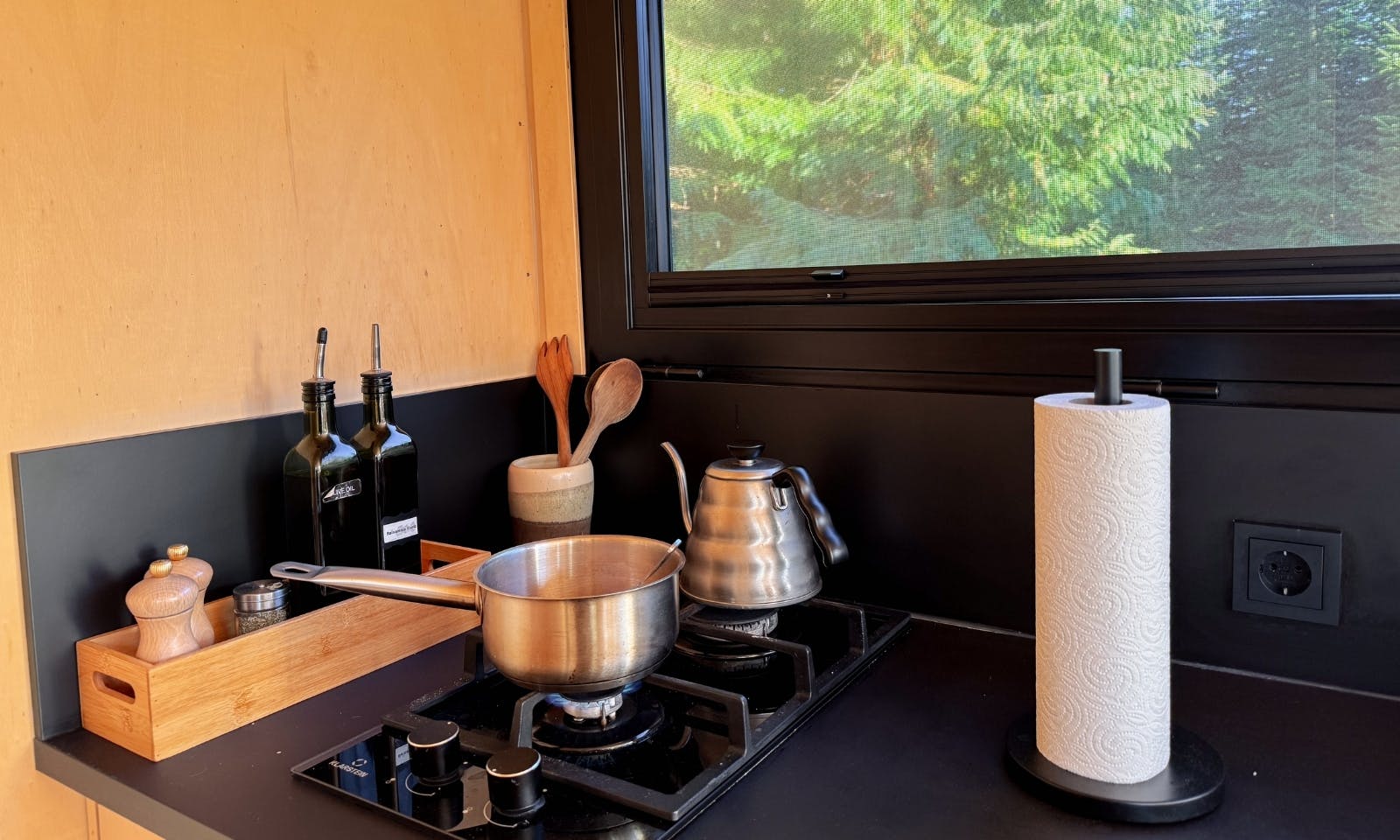 Ein Topf und ein Wasserkocher auf einem Herd in einem Raus Tiny House