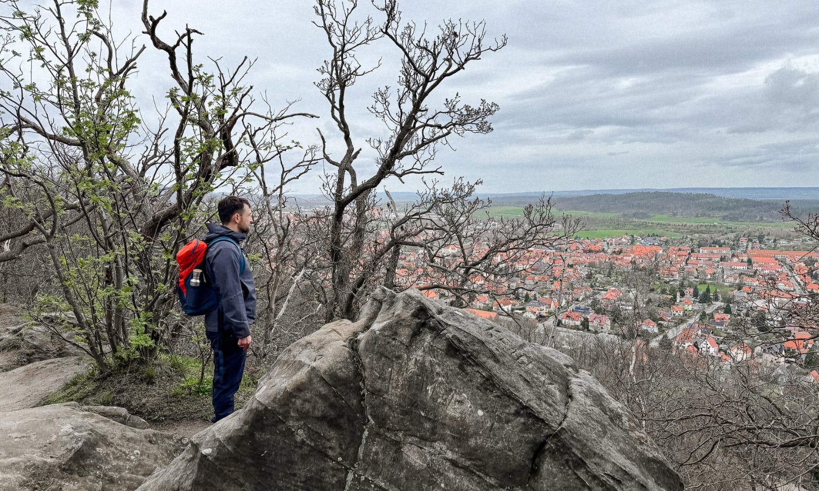 Mann mit Vaude Wanderrucksack mit Blick über Blankenburg auf der Teufelsmauer im Harz