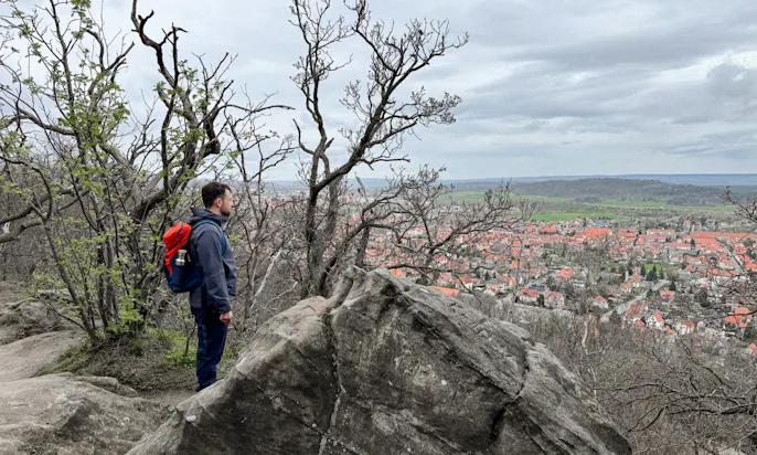 Mann mit Vaude Wanderrucksack mit Blick über Blankenburg auf der Teufelsmauer im Harz