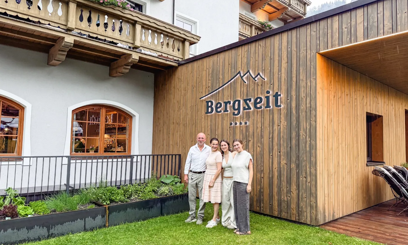 Die Betreiber des Bergzeit Hotels in Österreich stehen vor dem Bergzeit Hotel