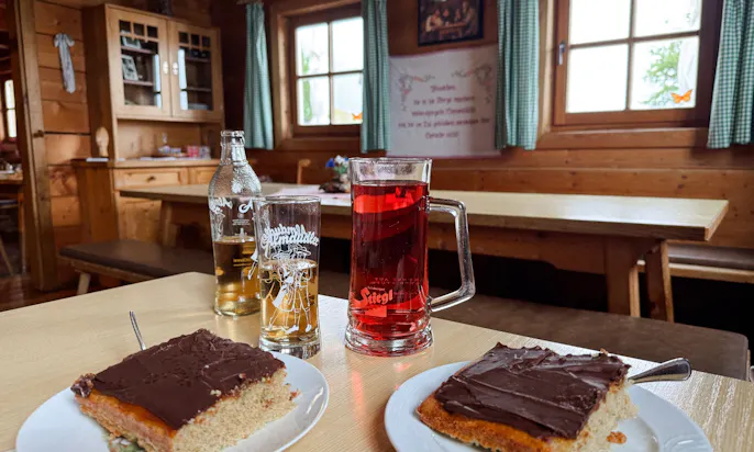 Zwei Stück Kuchen und Getränke auf einem Tisch in der Gerstreitalm in Großarltal