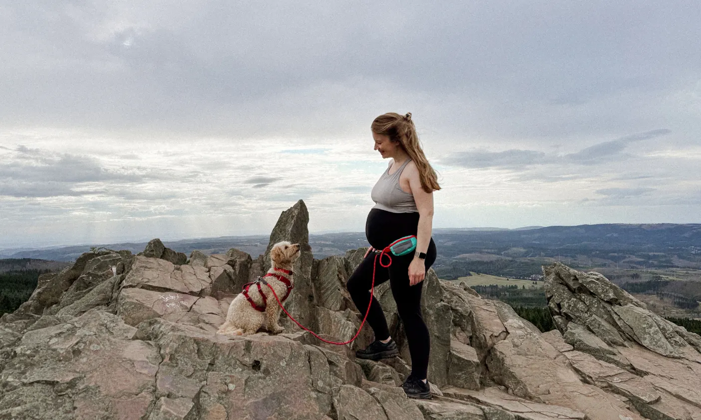 Schwangere mit Hund auf einem Berg