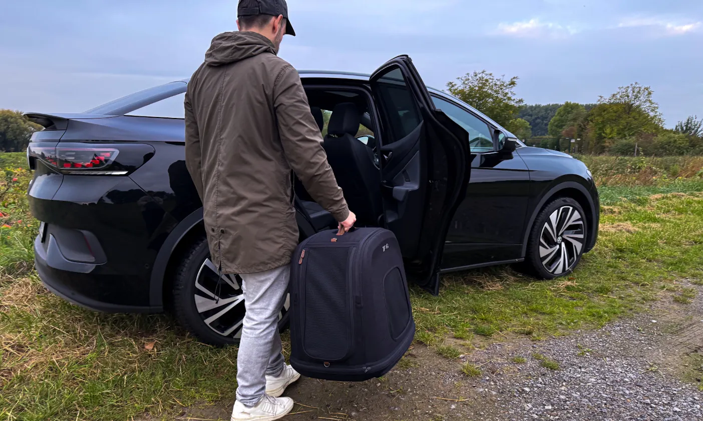 Ein Mann trägt die Tavo Crispin Hundebox zum Auto