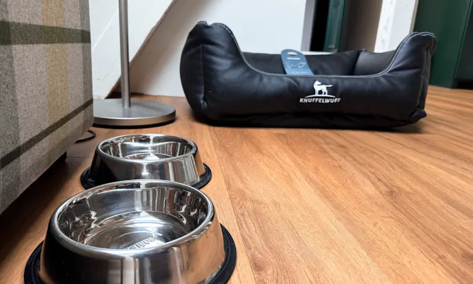 Zwei Hundenäpfe und ein Hundebett in einer Familiensuite des Hotel & Spa Suiten FreiWerk in Stolberg