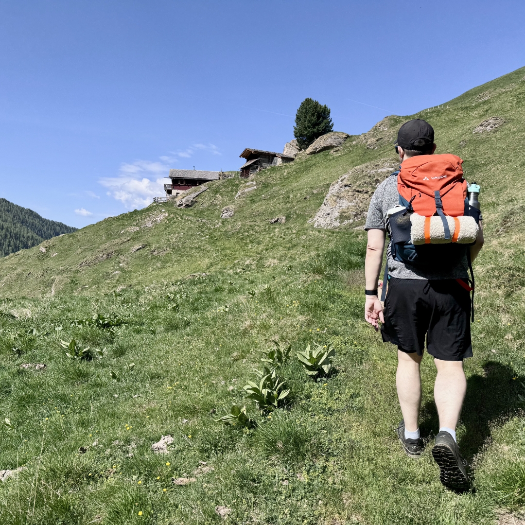 Mann beim Wandern mit Rucksack und Hundedecke