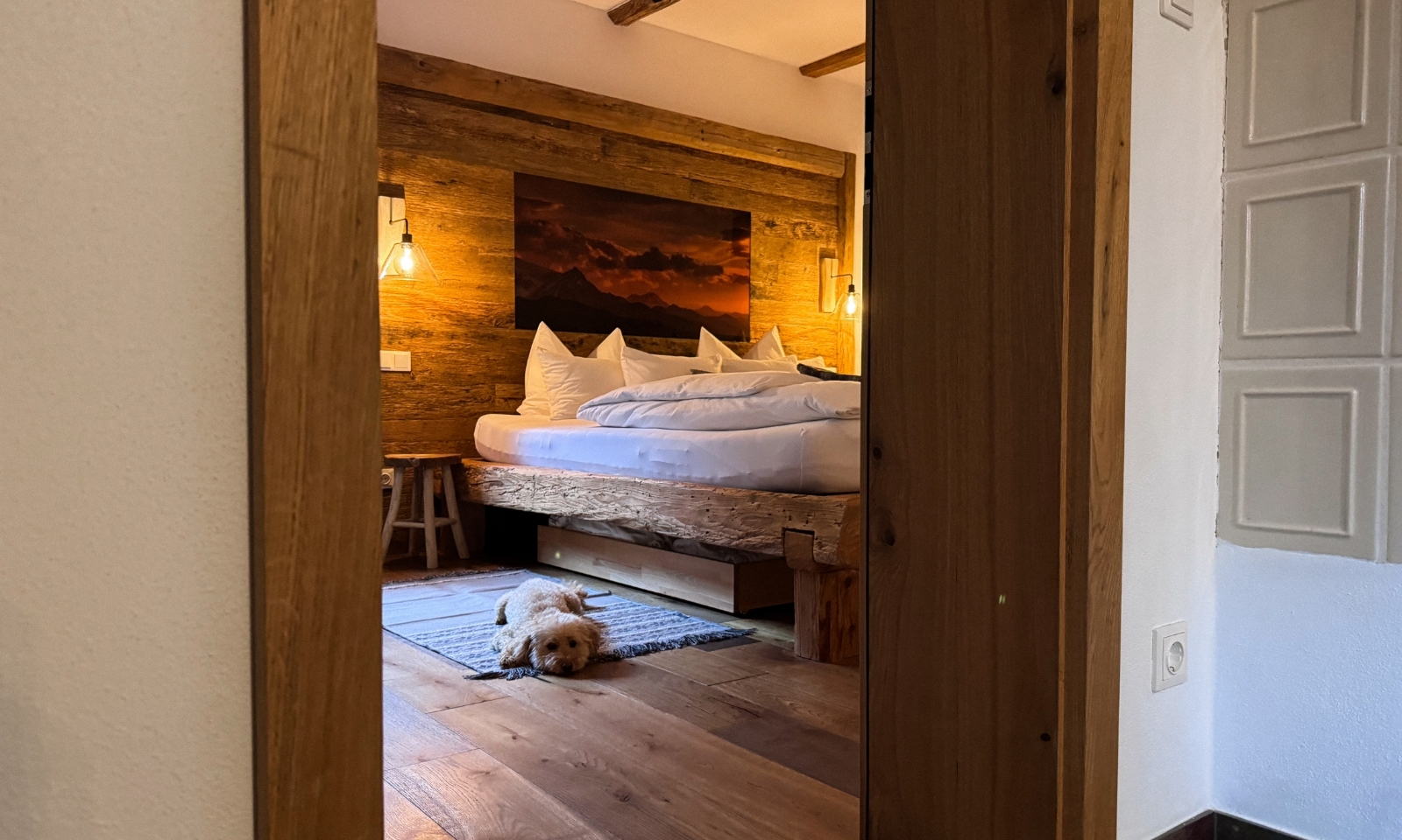 Goldendoodle liegt vor dem Bett im Eichenchalet