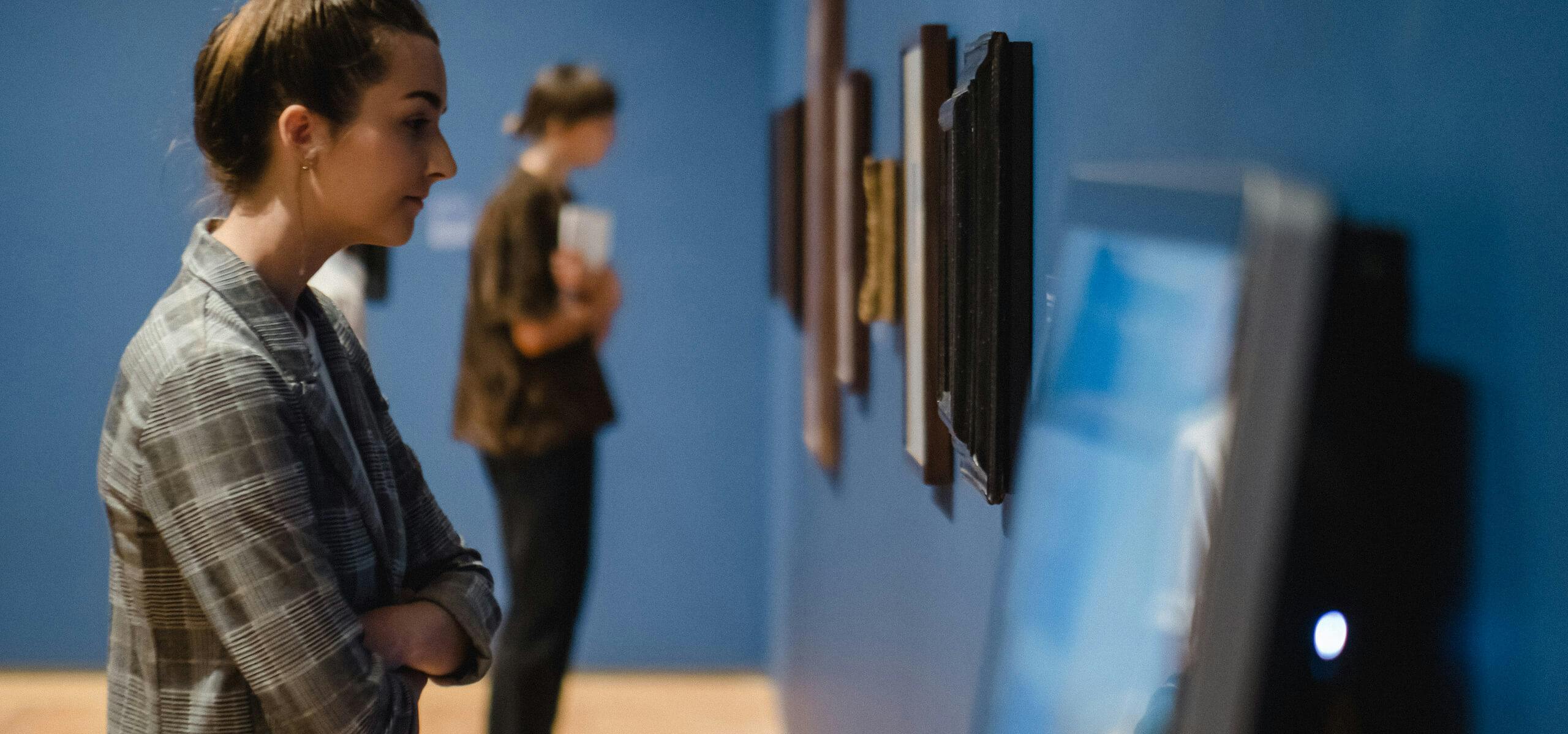 A woman looking at large touchscreen kiosk displaying the interactive map Rembrandt's Leiden, on display in the exhibit Leiden circa 1630: Rembrandt Emerges at the Agnes Etherington Art Centre.