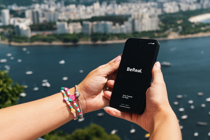 Hands holding a phone with the Be real app on it. 