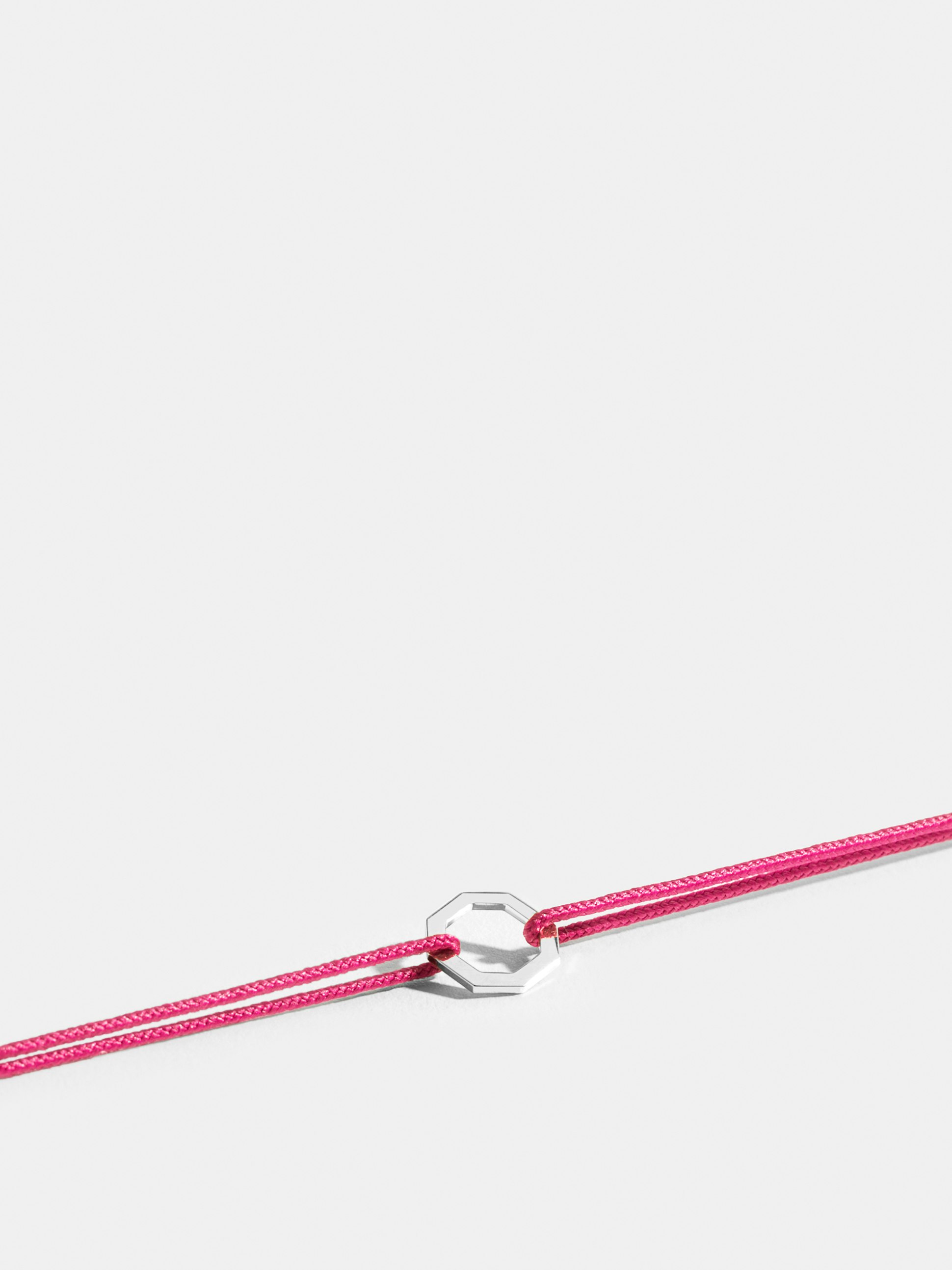 Octogone motif in 18k Fairmined ethical white gold, on a fuschia pink cord. 