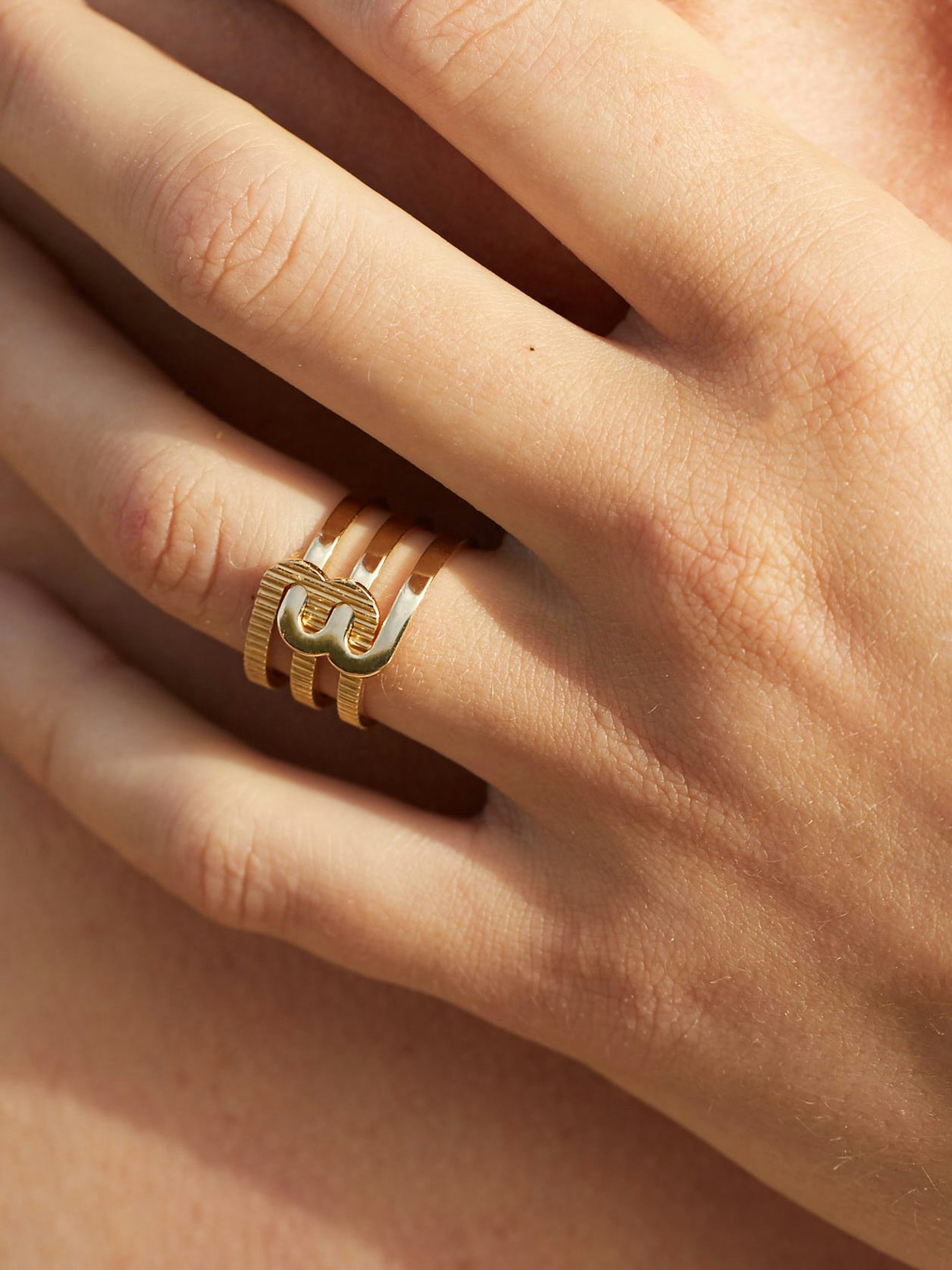 Bague Étreintes en Or jaune éthique 18 carats certifié Fairmined composée d'une demi-bague double finition poli-brillant et d'une demi-bague double finition godronnée.