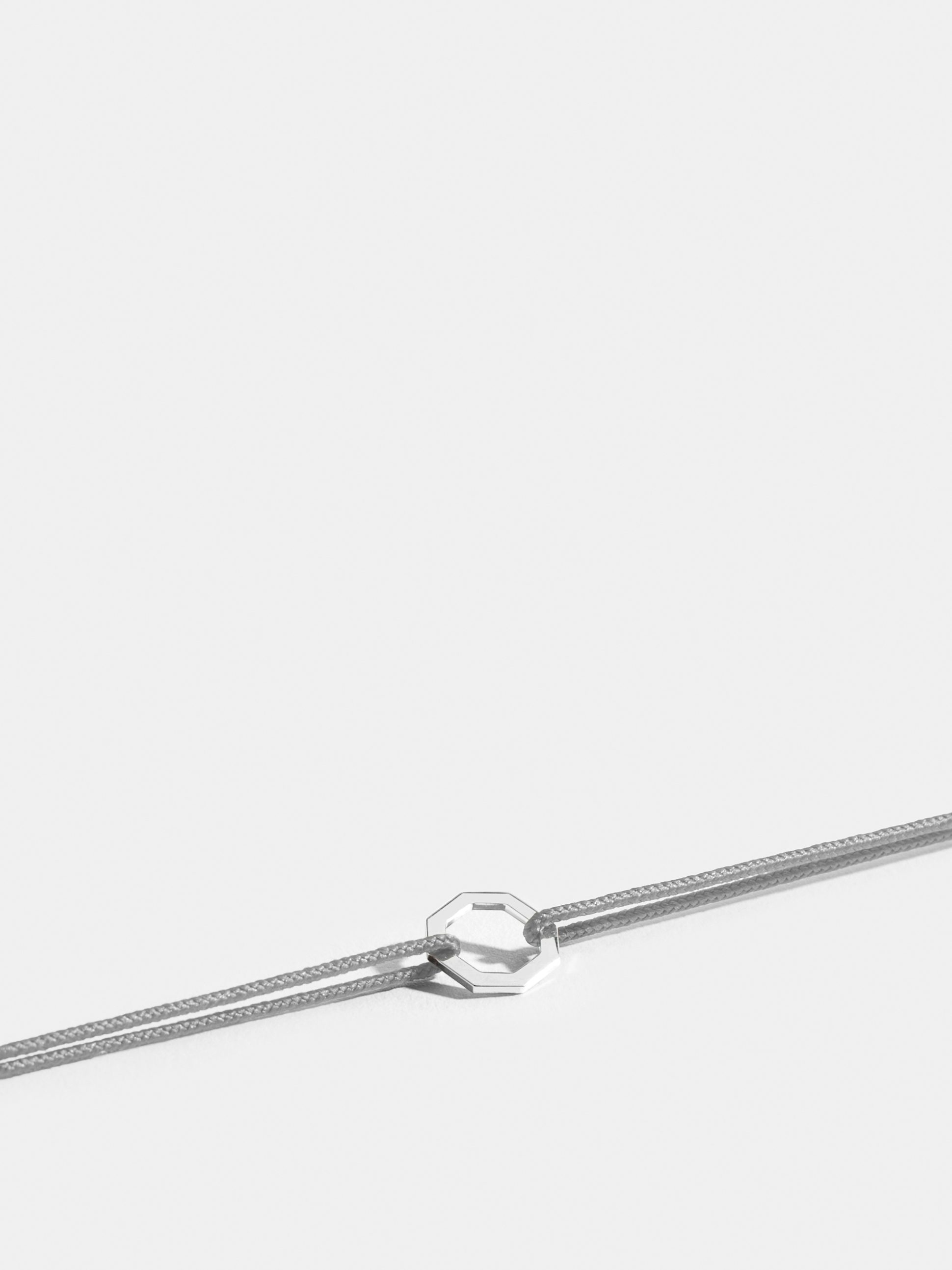 Motif Octogone en Or blanc éthique 18 carats certifié Fairmined, sur cordon gris perlé.