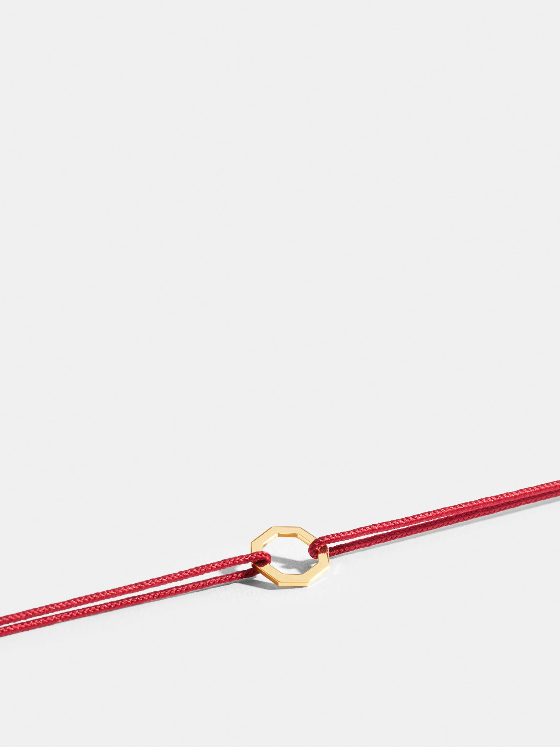 Octogone motif in 18k Fairmined ethical yellow gold, on a poppy red cord.