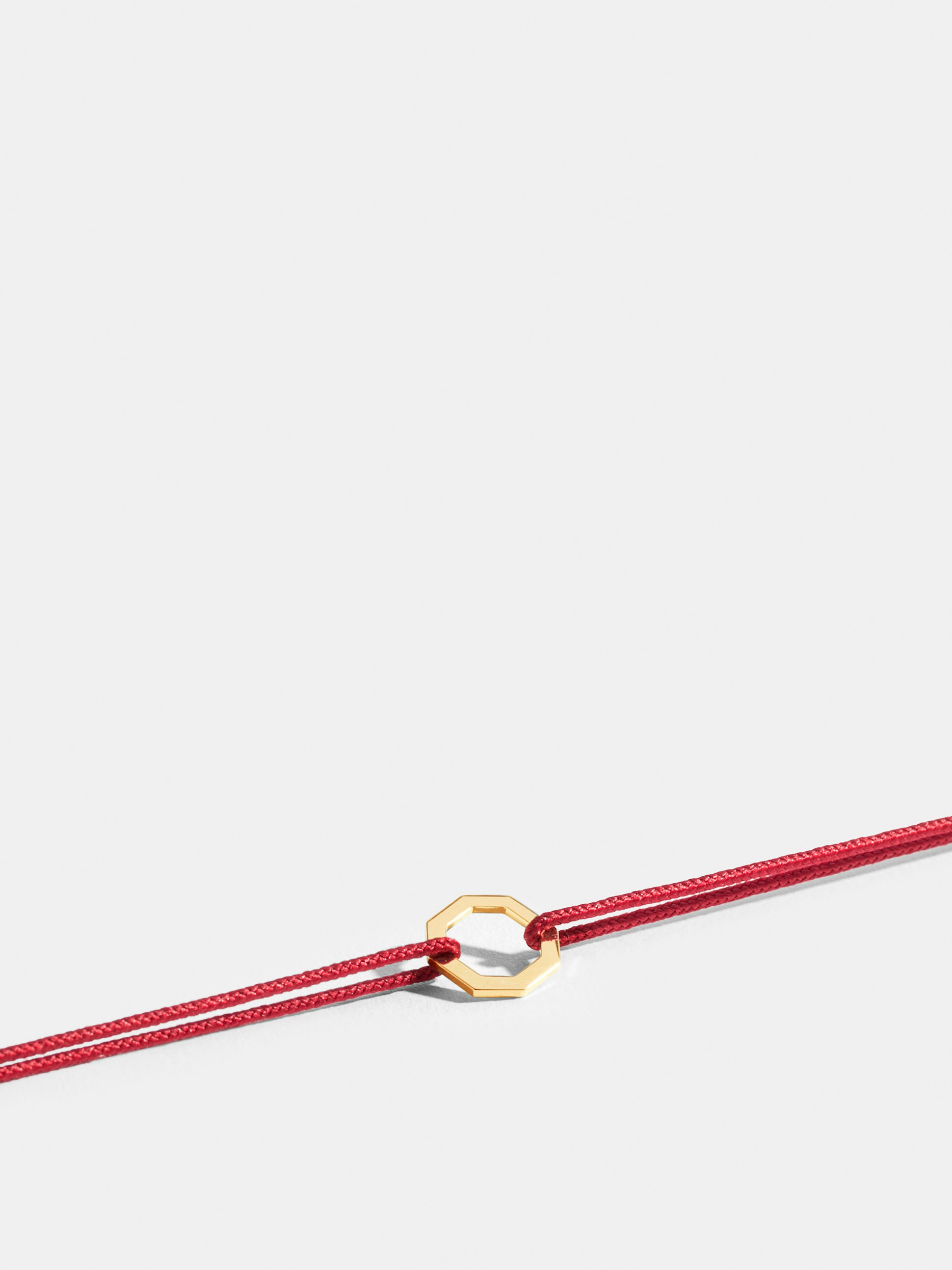 Octogone motif in 18k Fairmined ethical yellow gold, on a poppy red cord. 