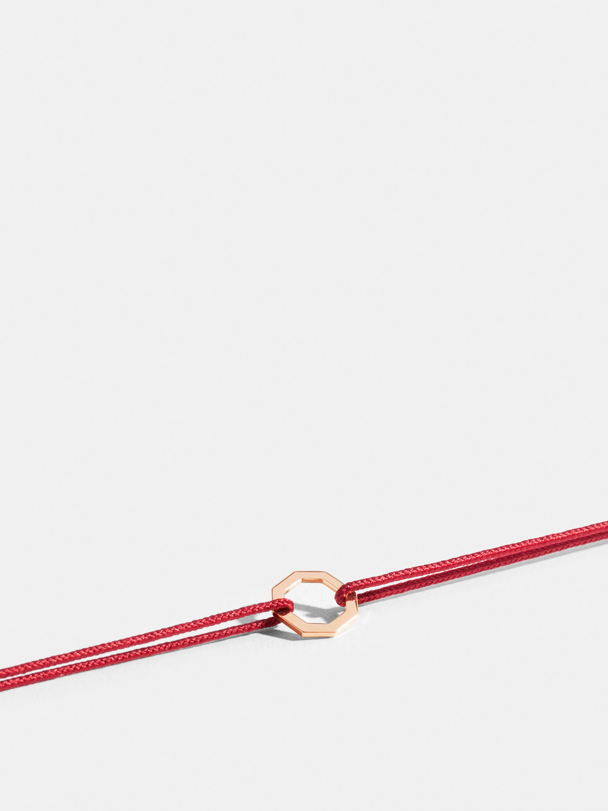 Octogone motif in 18k Fairmined ethical rose gold, on a poppy red cord. 