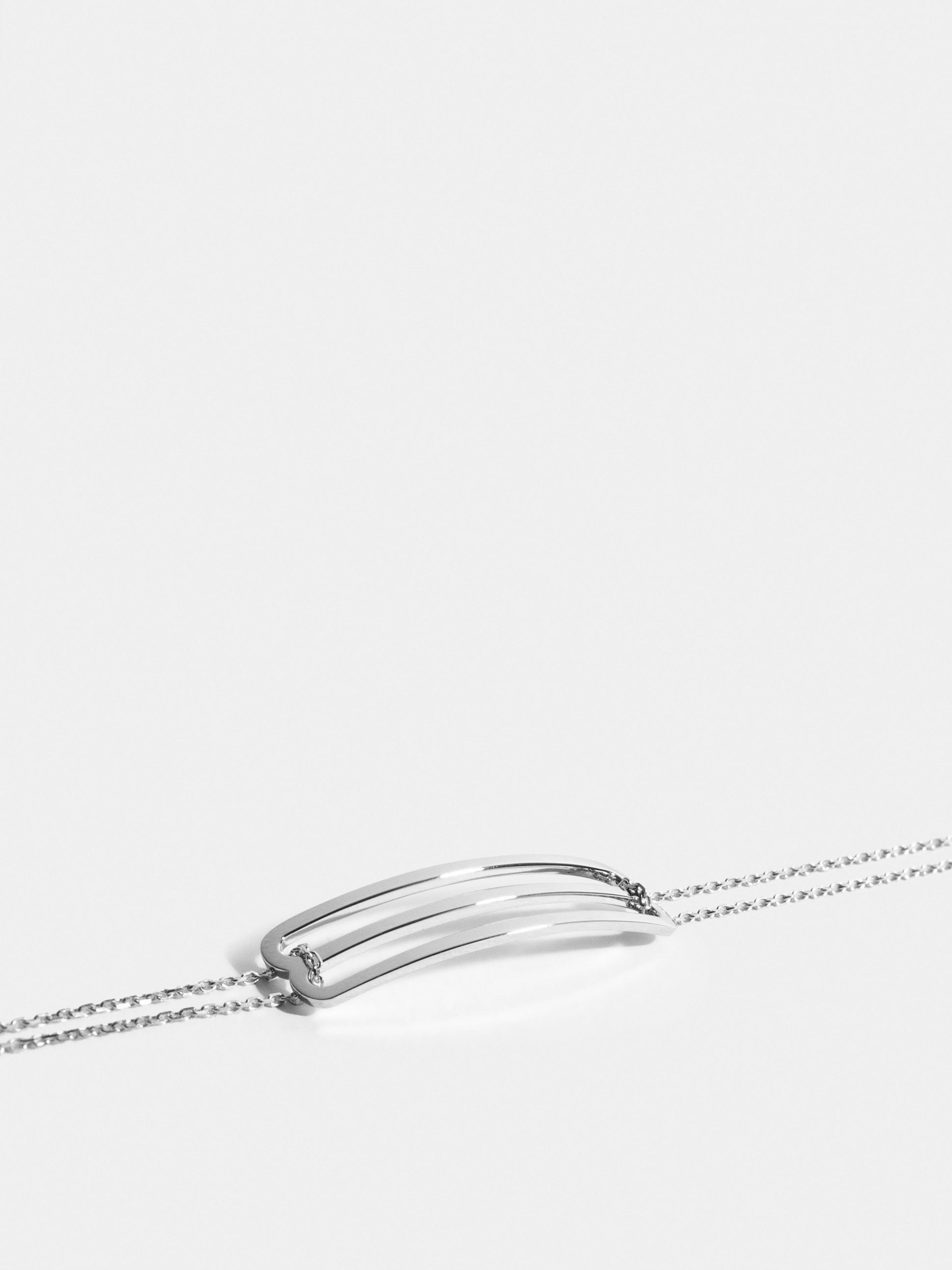 Motif Étreintes en Or blanc éthique 18 carats certifié Fairmined, sur chaîne.