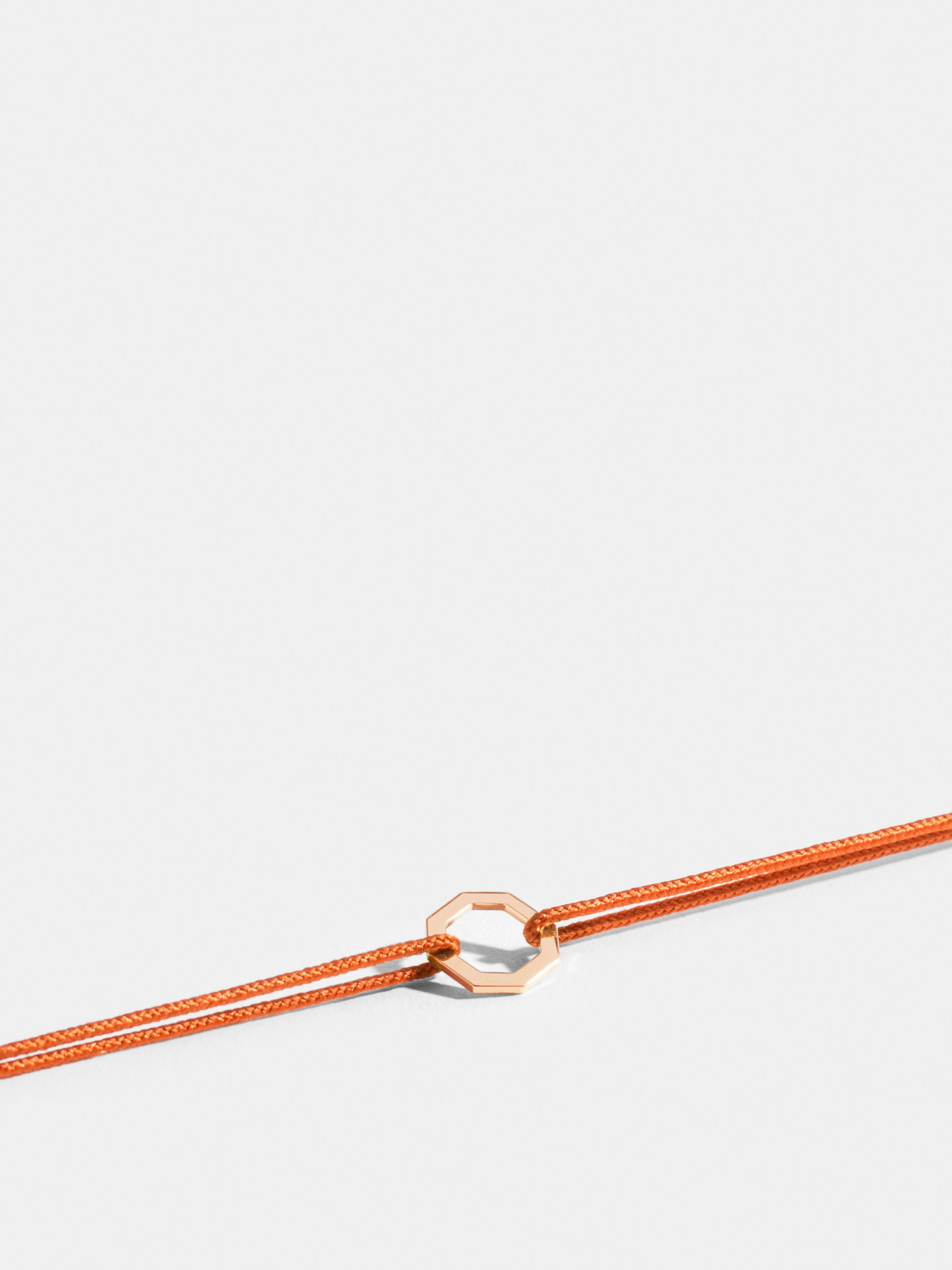 Octogone motif in 18k Fairmined ethical rose gold, on a bright orange cord. 