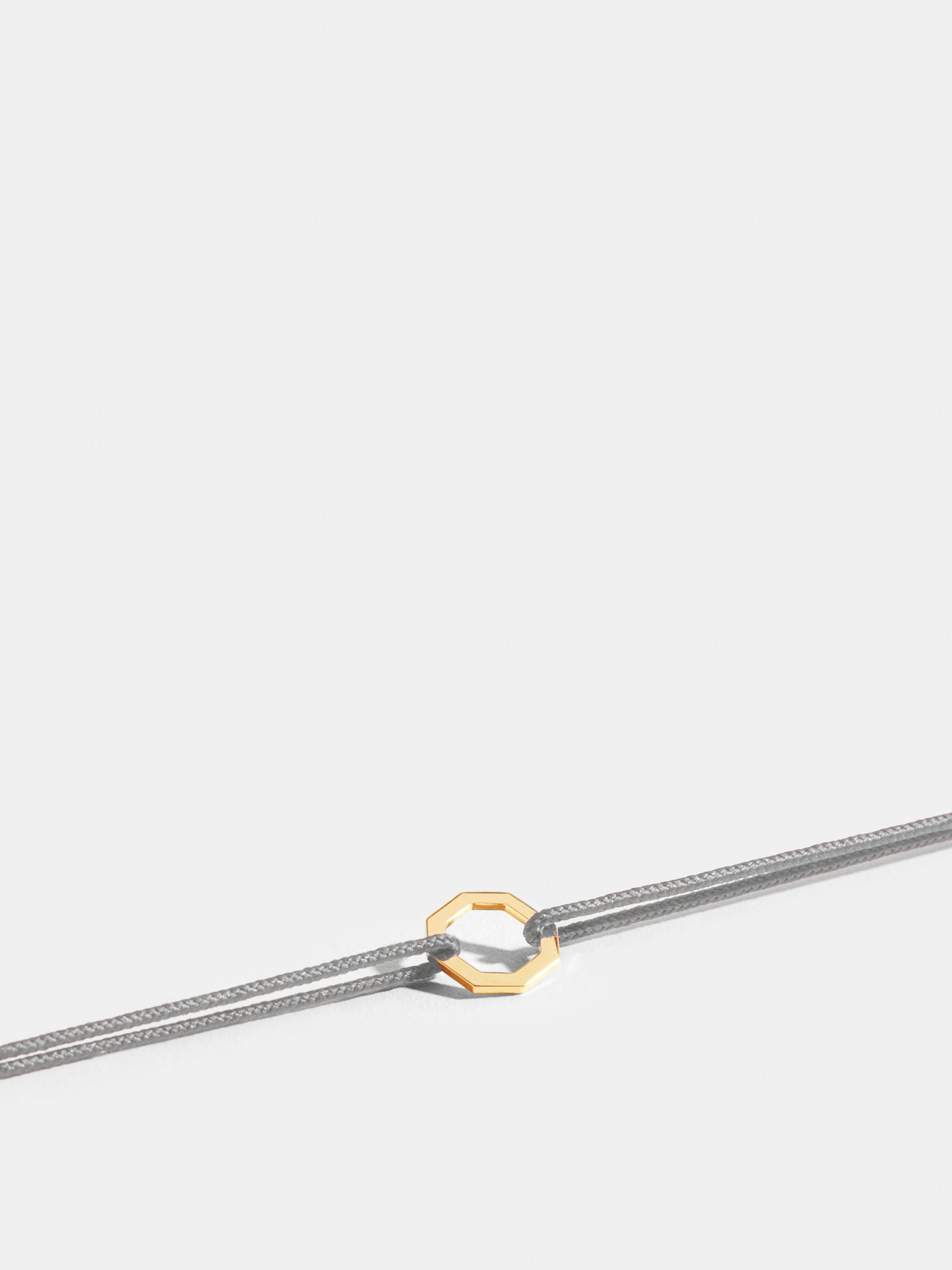 Octogone motif in 18k Fairmined ethical yellow gold, on a pearl grey cord. 