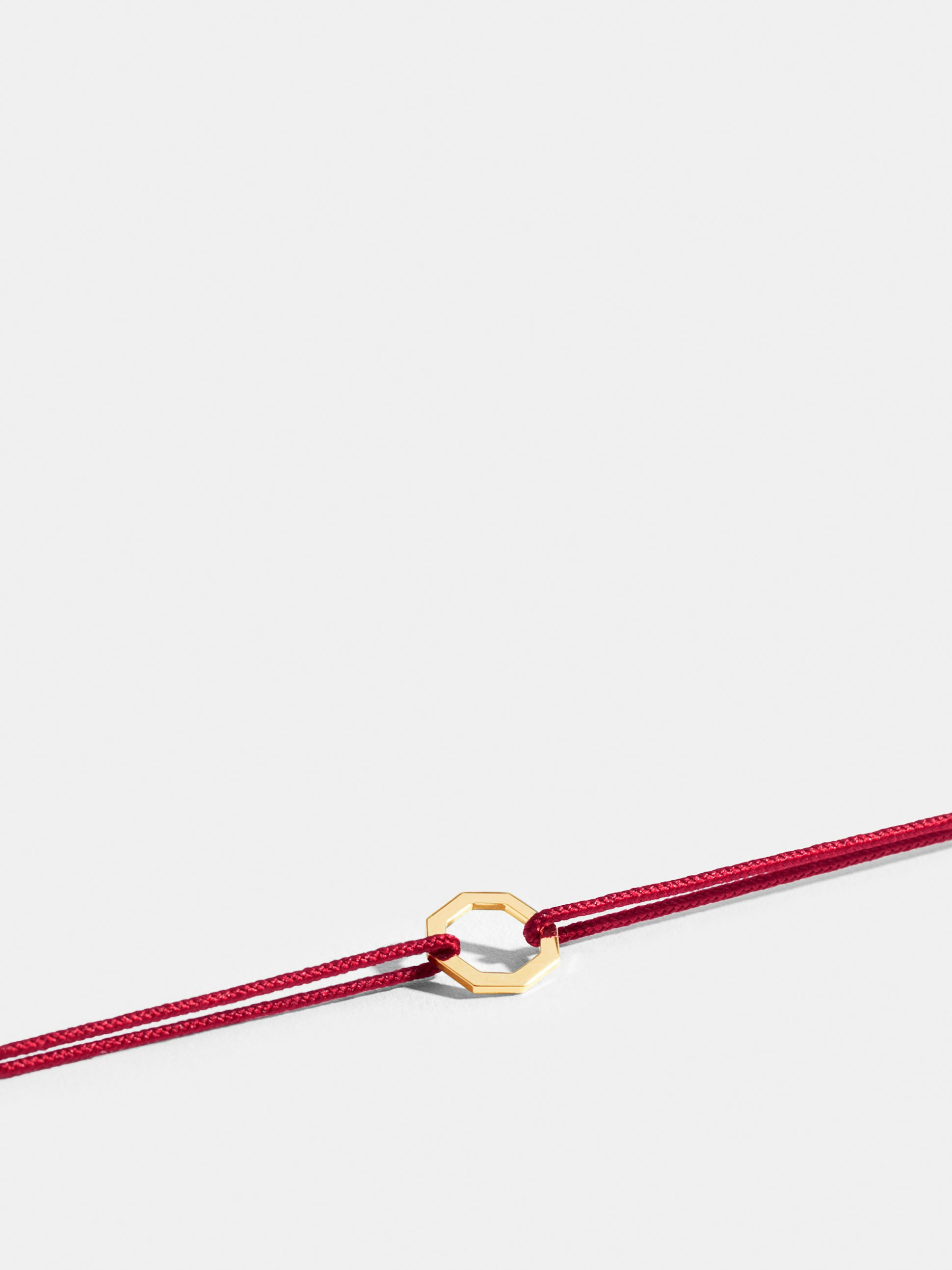 Octogone motif in 18k Fairmined ethical yellow gold, on a carmine red cord. 