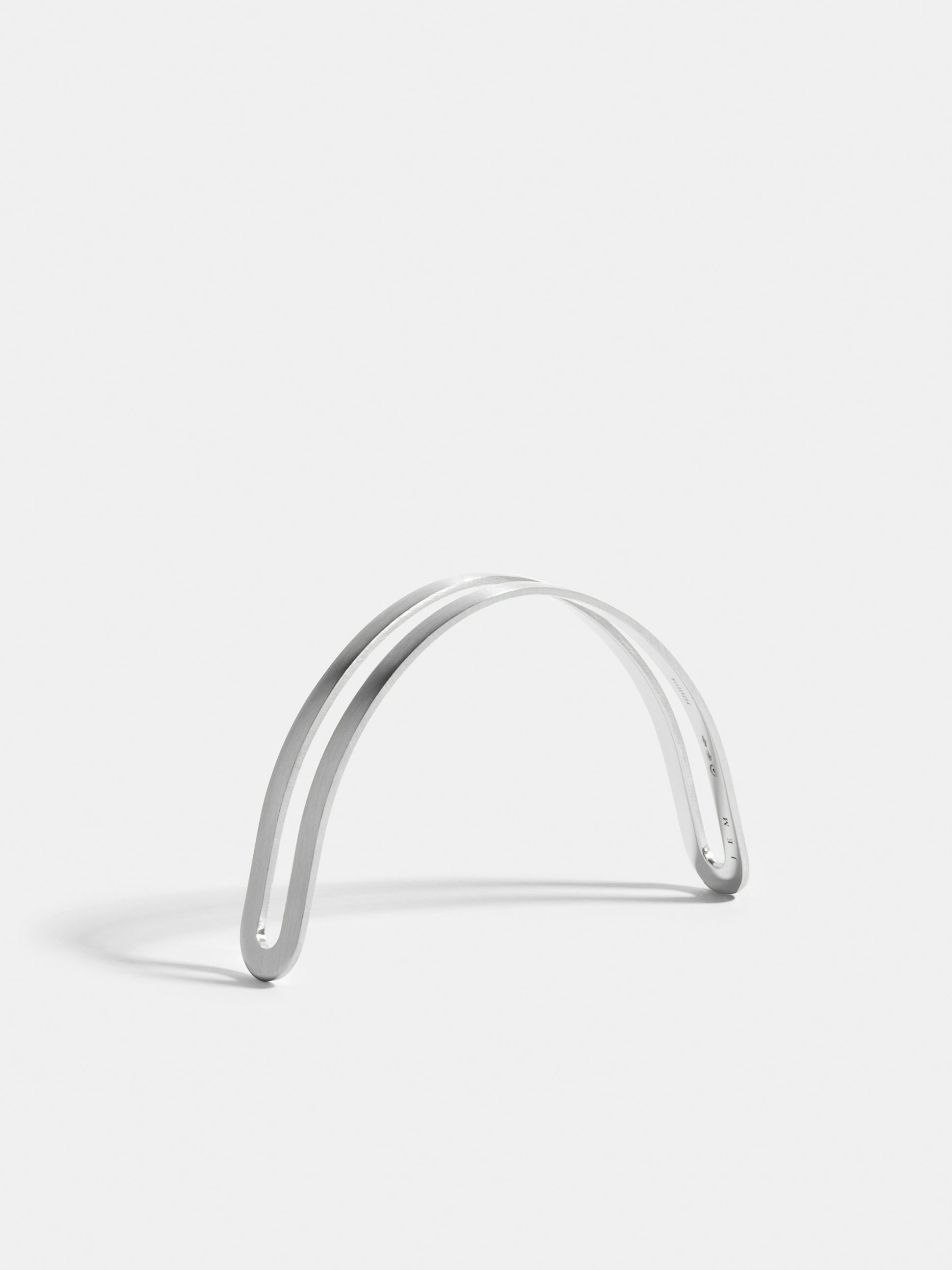 Étreintes simple half-bracelet in 18k Fairmined ethical white gold with a brushed finish.