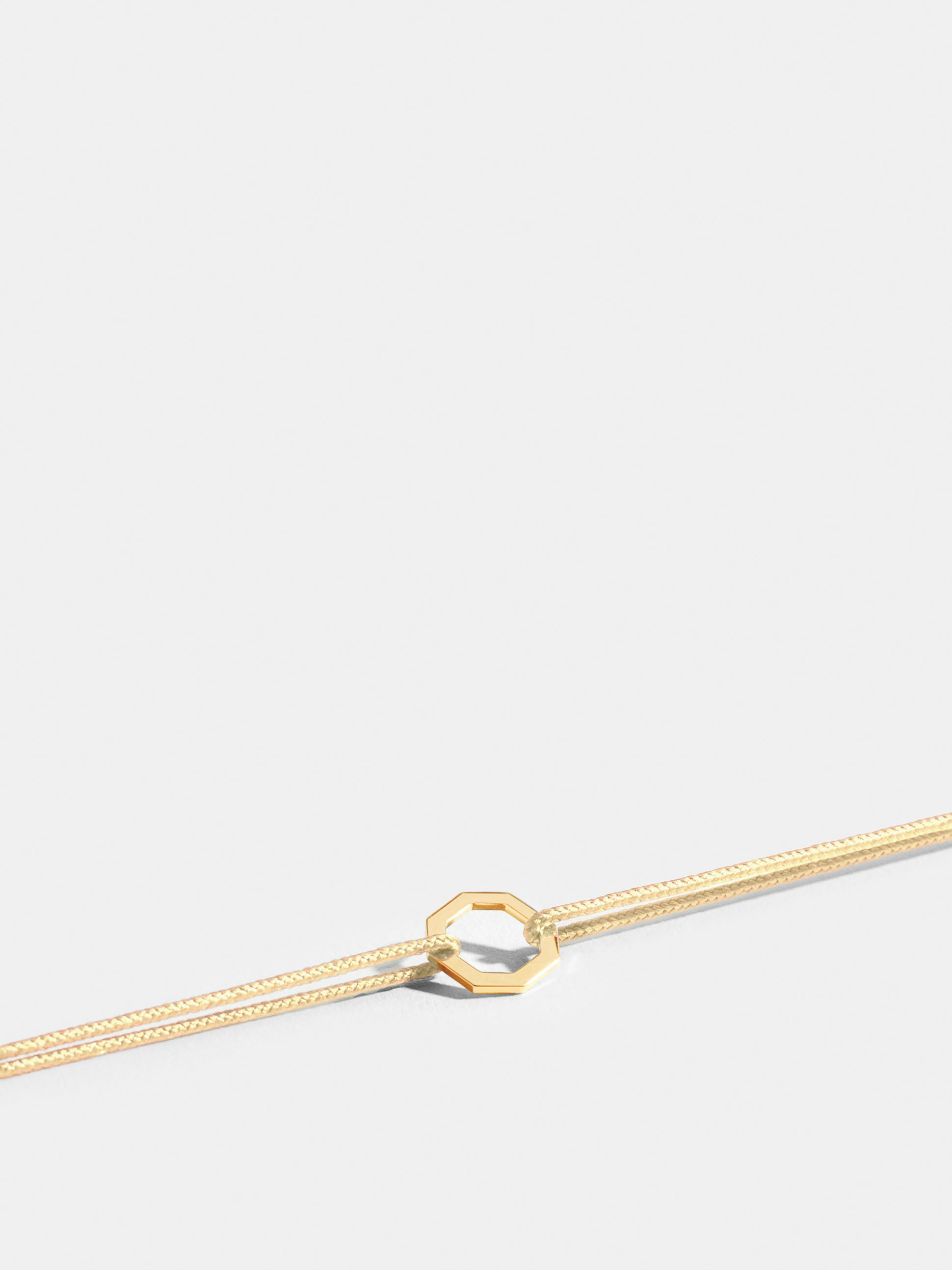 Octogone motif in 18k Fairmined ethical yellow gold, on an ivory white cord. 