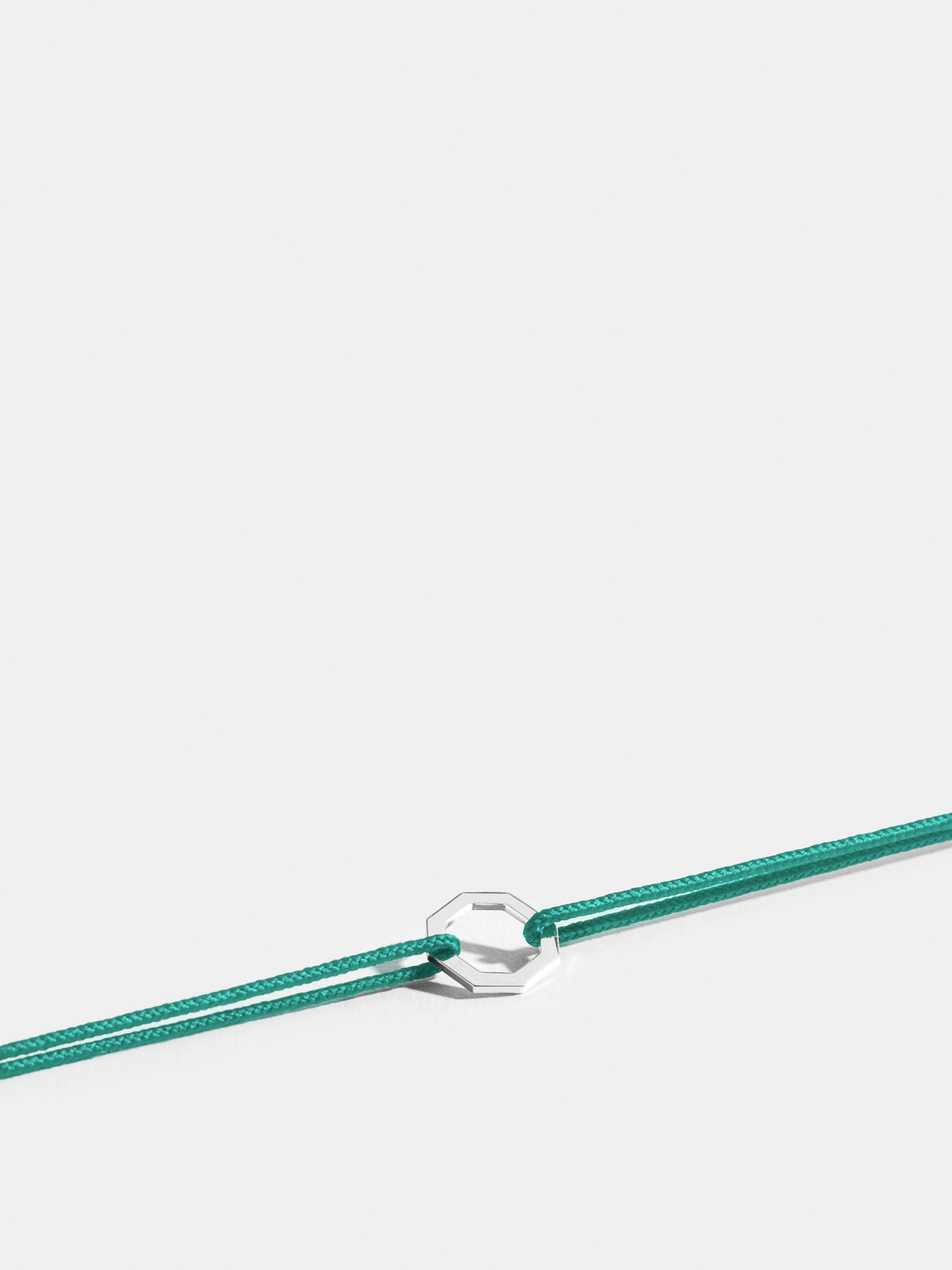 Octogone motif in 18k Fairmined ethical white gold, on a turquoise blue cord. 