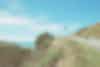 A road leading up into the sky, there is a cyclist.