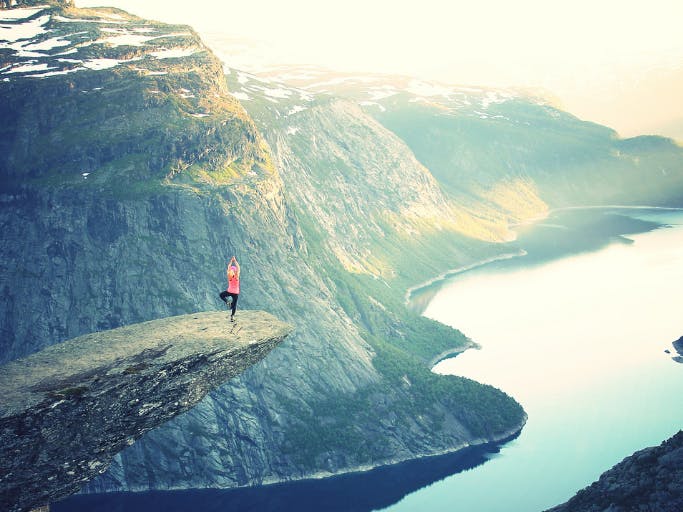 person doing yoga on a cliff