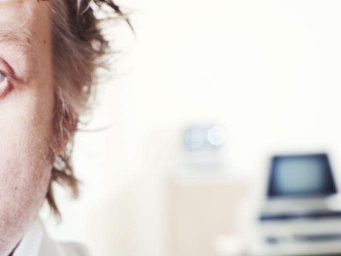 man standing in front of old computer