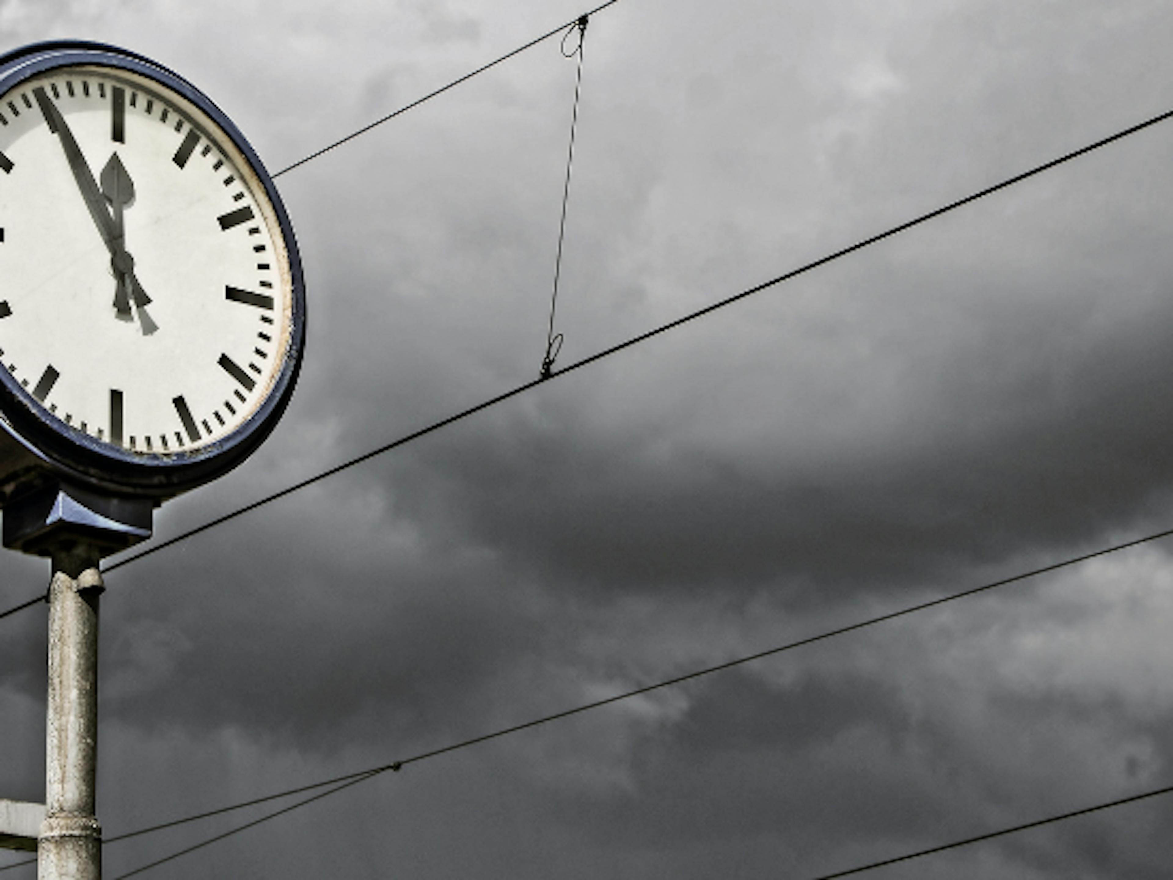 clock in front of storm clouds