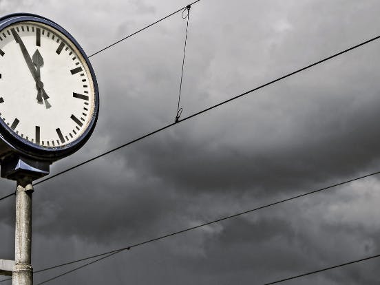 clock in front of storm clouds