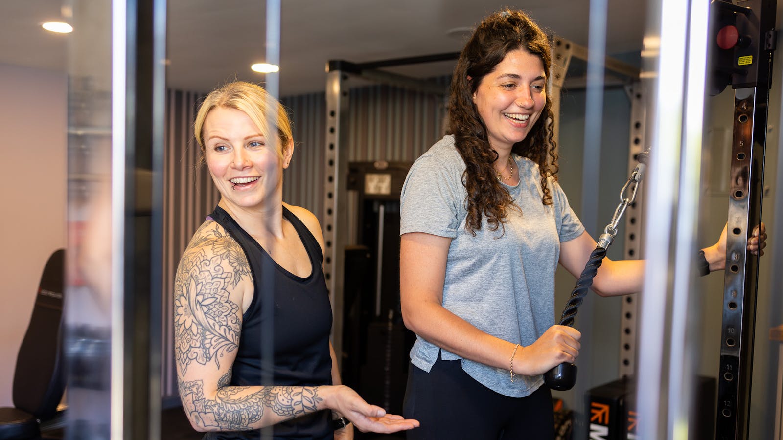 PT talking to a client on a cable machine in Jess-fit studio