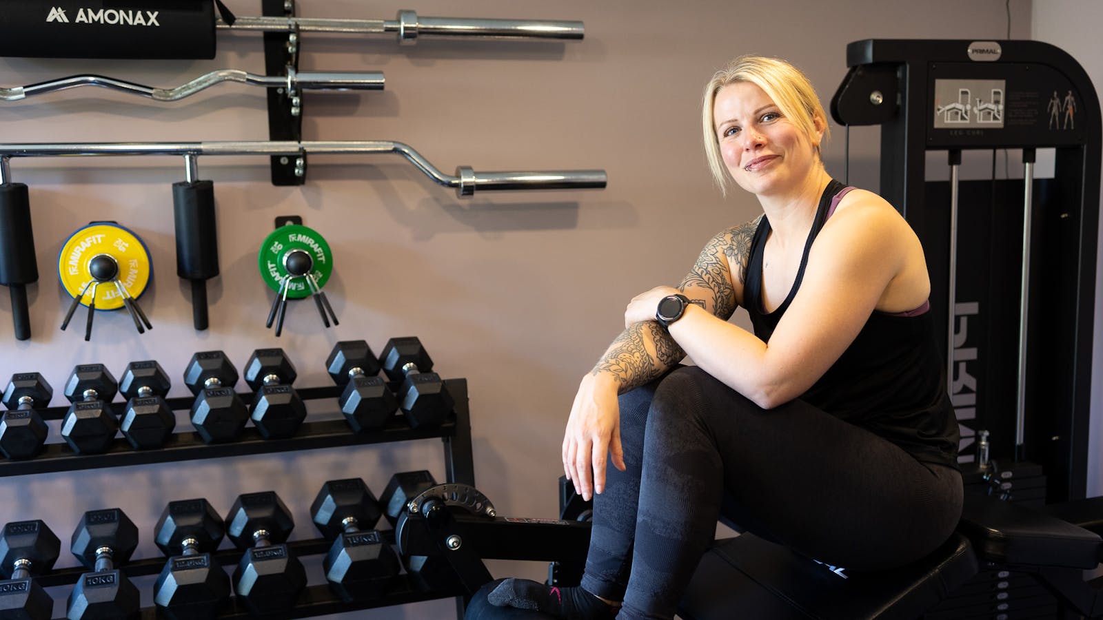 Jess sits on equipment in Jess-fit studio