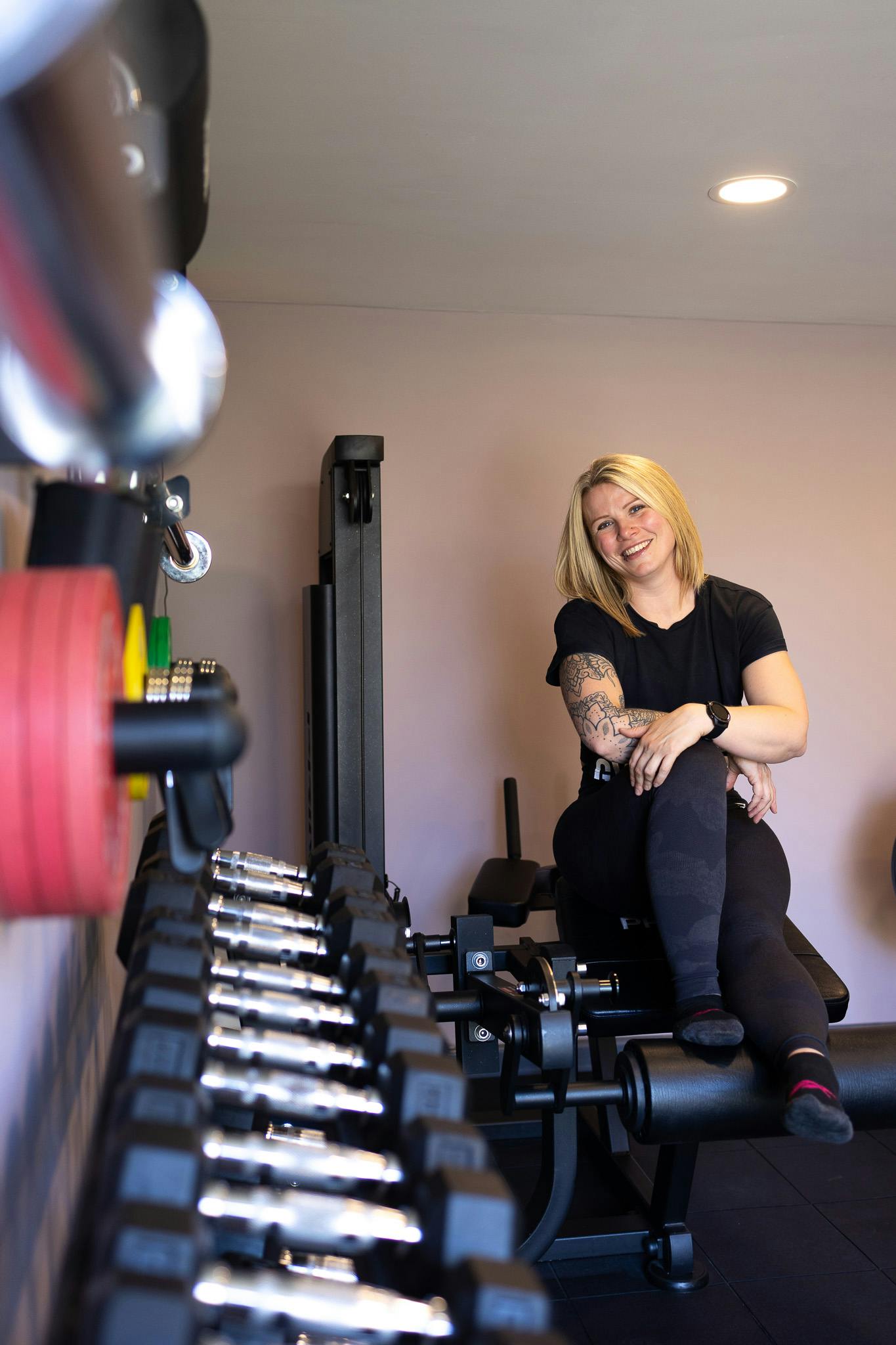 Jess sits on equipment in Jess-fit studio