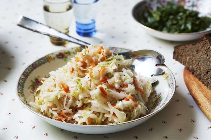 Sauerkraut with slice of black bread, glasses of vodka and bowl of parsley.