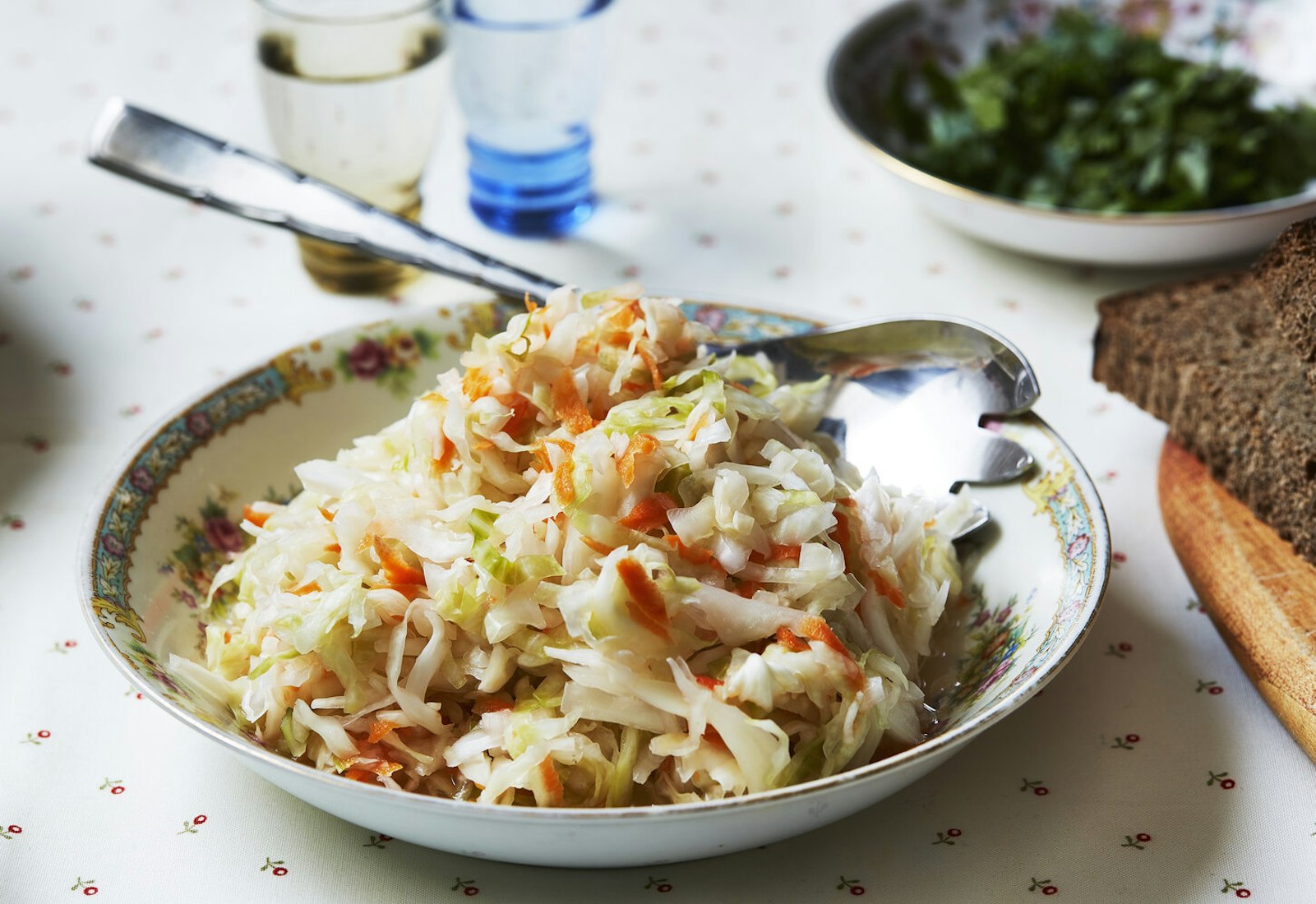 Sauerkraut with slice of black bread, glasses of vodka and bowl of parsley.