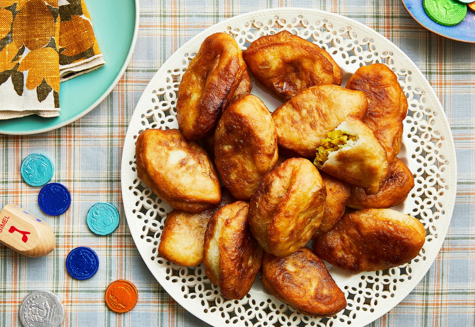Sambousak on white plate atop checkered tablecloth.