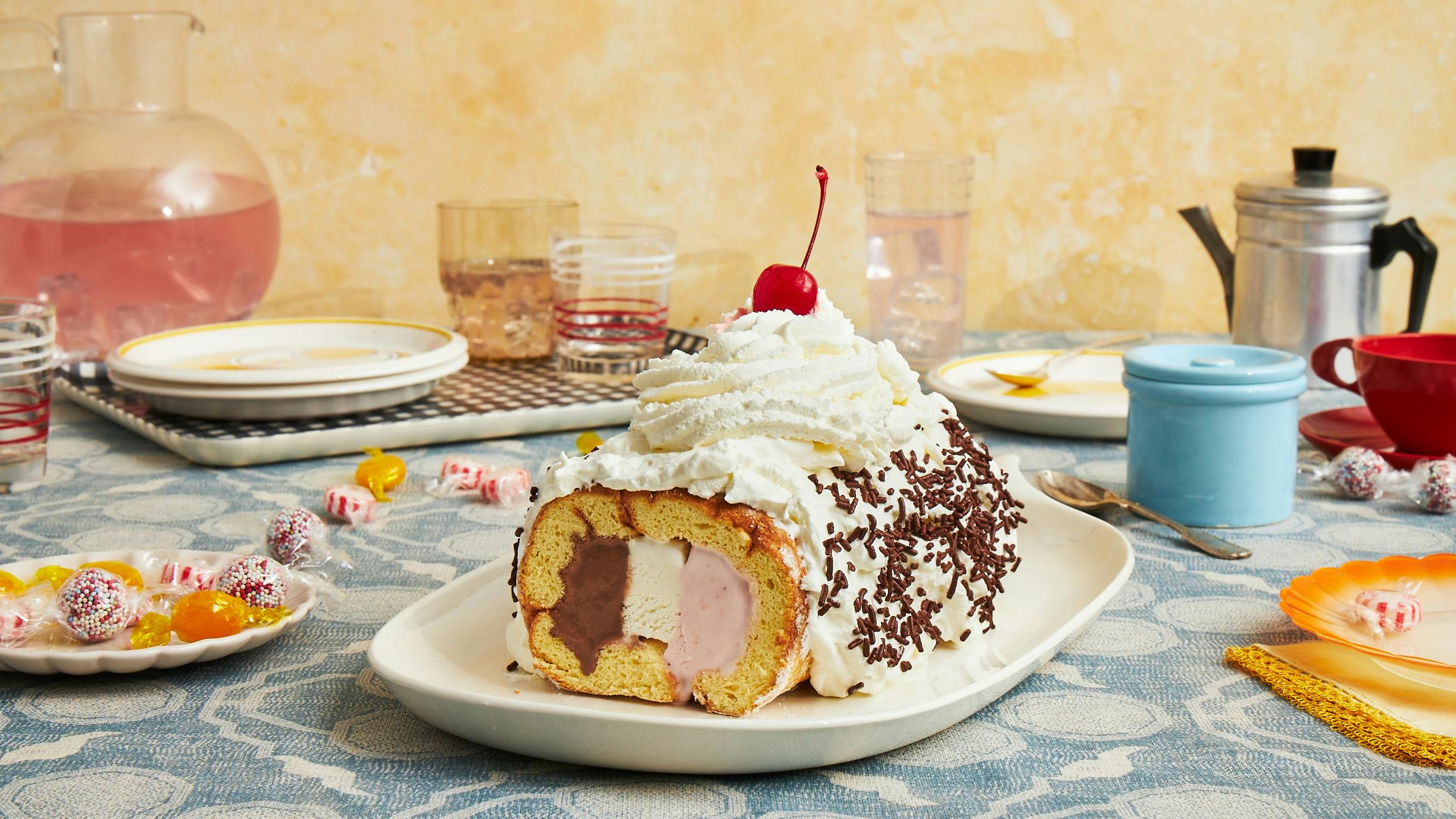 Neapolitan ice cream cake over blue tablecloth.