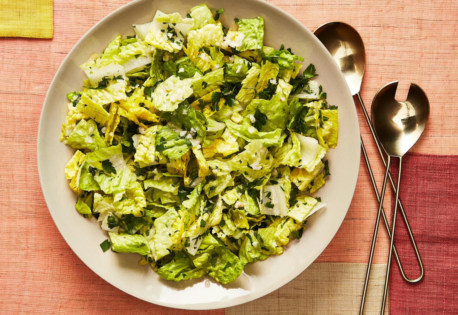 Lettuce and parsley salad alongside serveware.