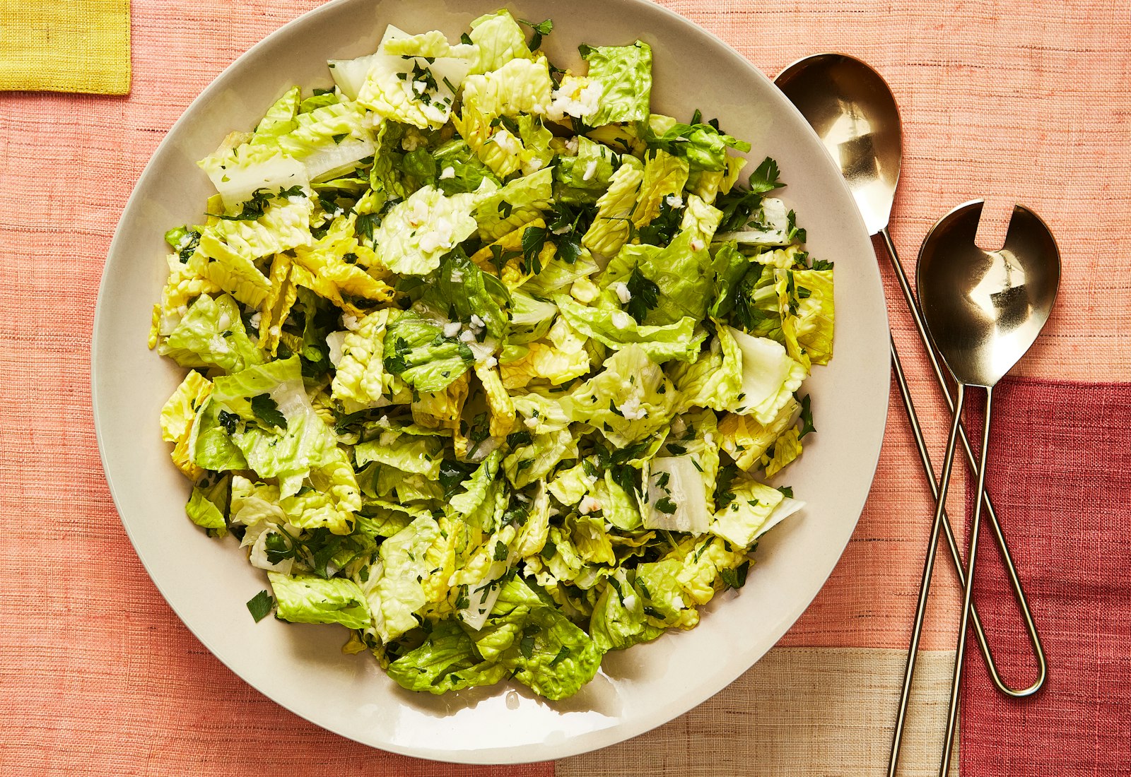 Lettuce and parsley salad alongside serveware.