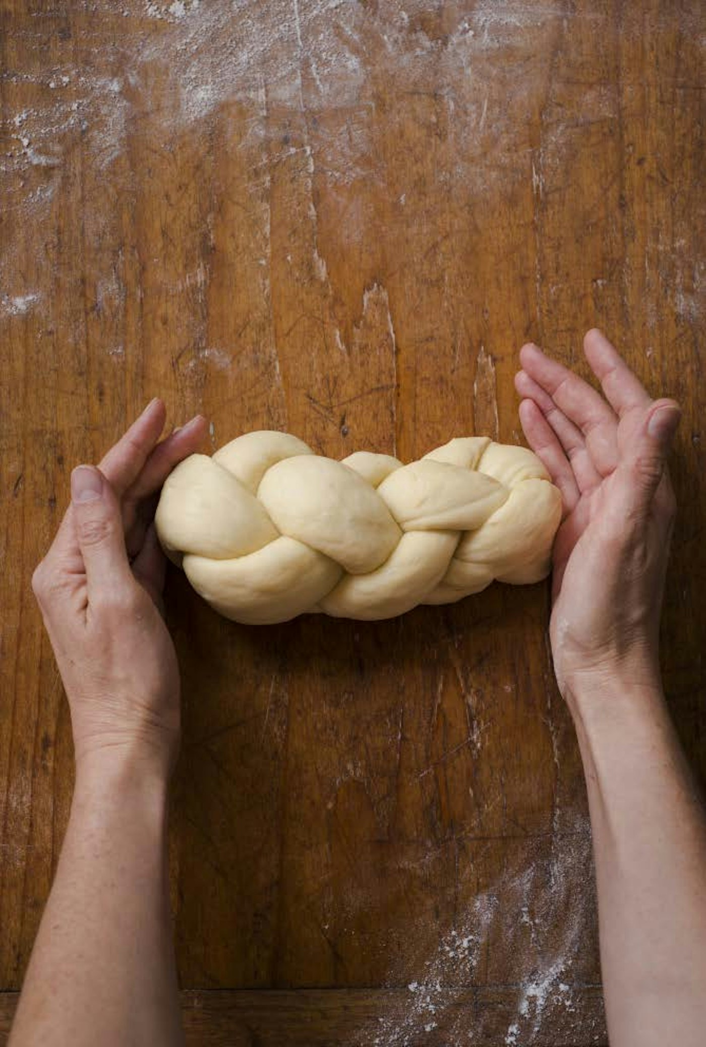 Chef preparing braided challah dough.