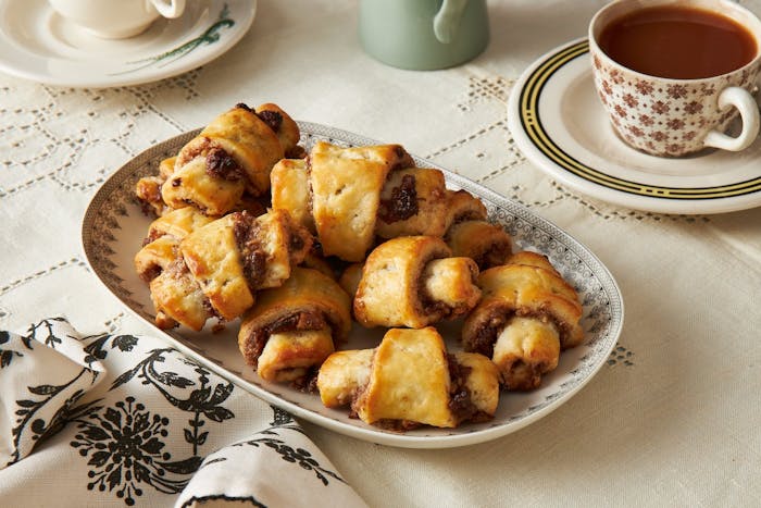 Rugelach cookies with coffee and patterned napkin.