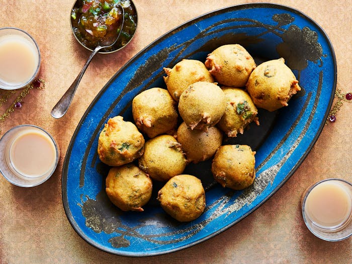 Batata vada with chutney alongside glasses of masala chai.