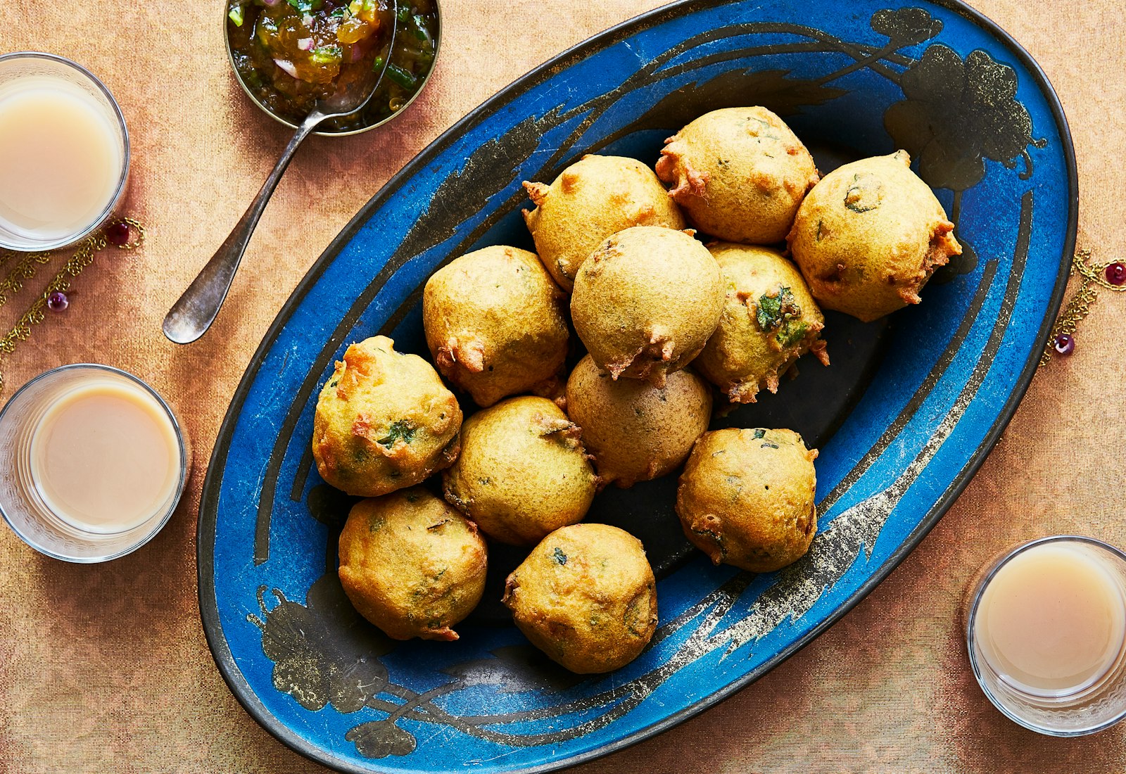 Batata vada with chutney alongside glasses of masala chai.
