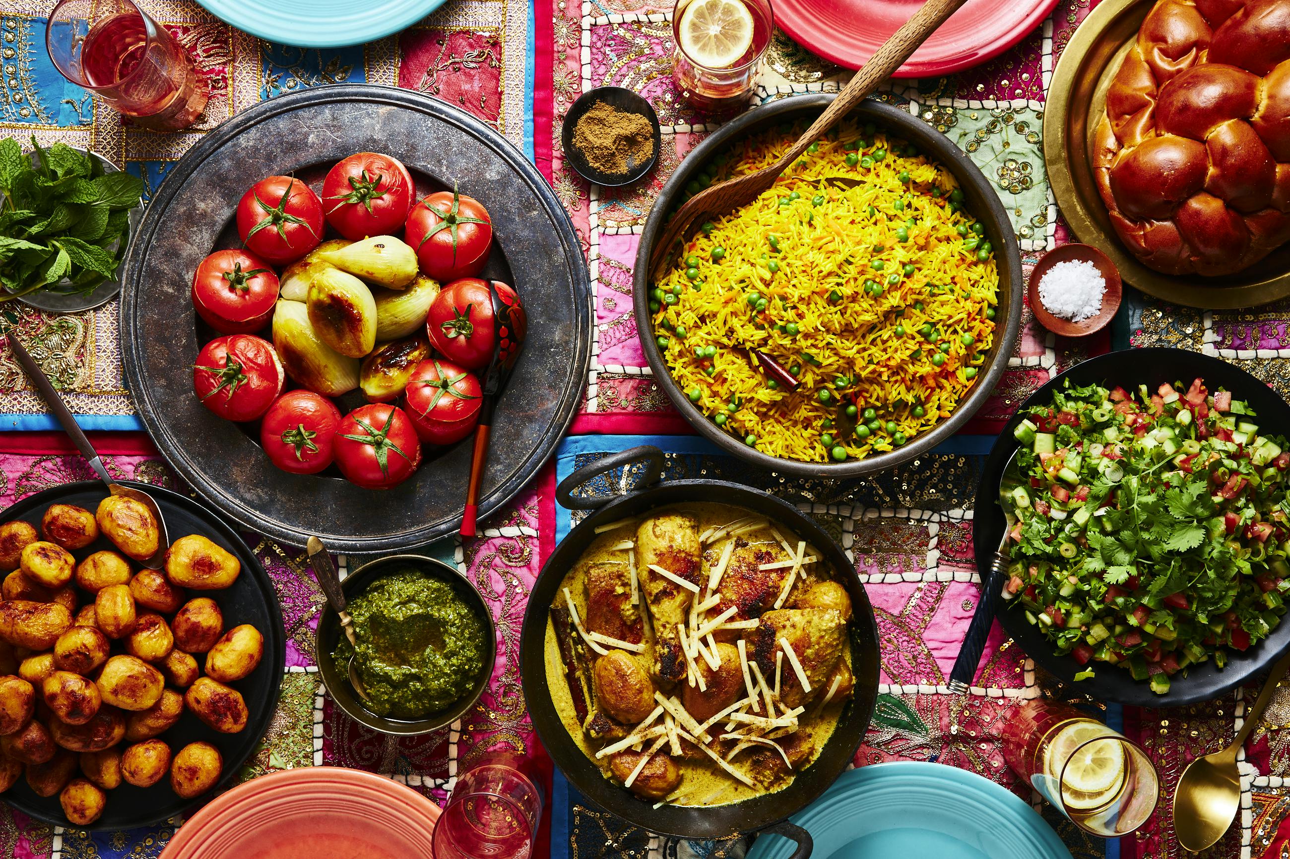 Vibrant shabbat table with spread of Indian-Baghdadi Jewish dishes.