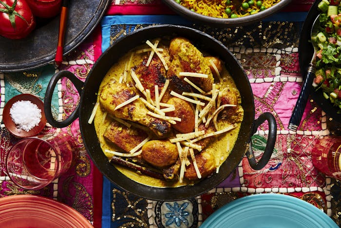 Spayty in cast iron pot alongside mahasha and rice pilau atop vibrant tablecloth.