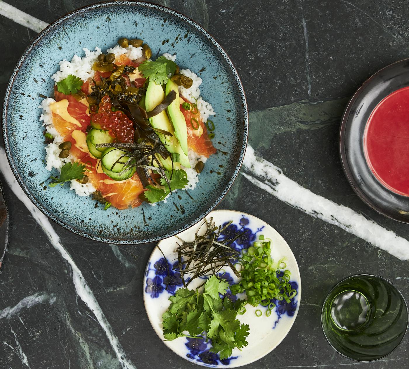 Serving of lox bowl alongside fresh garnishes.